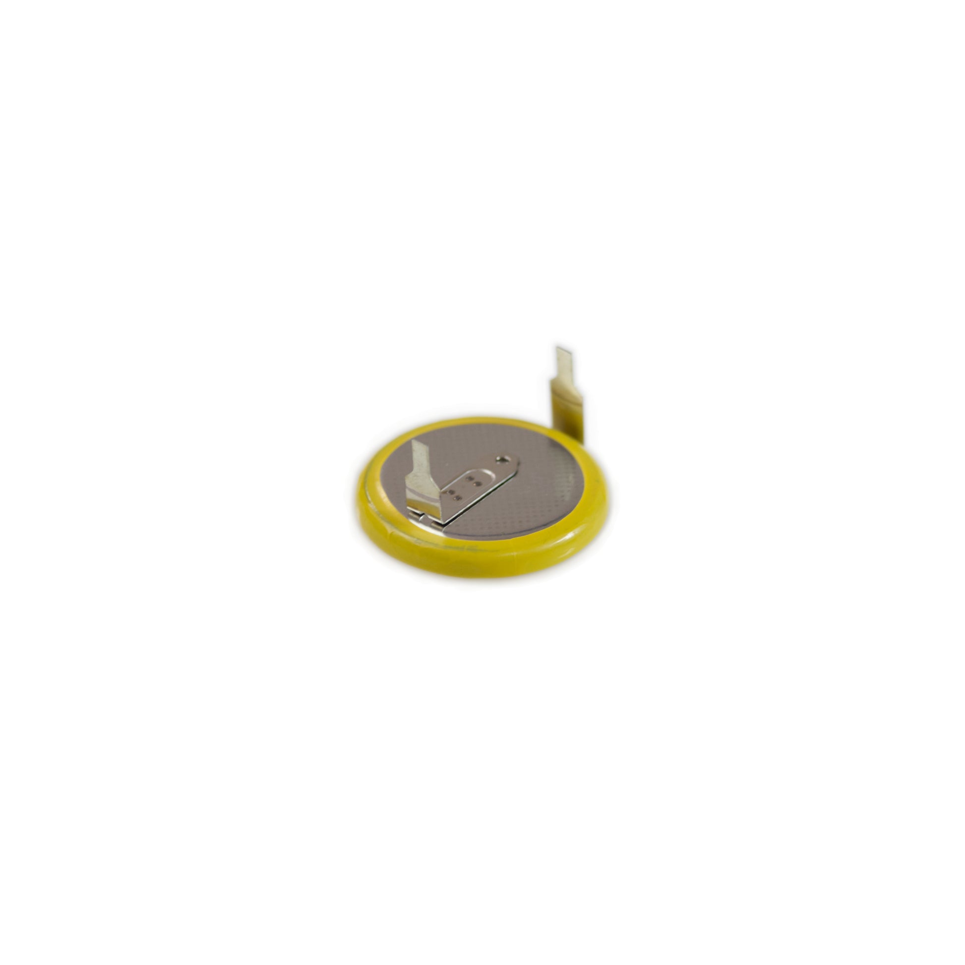close-up of a small round battery with yellow edge and metal connectors on white background