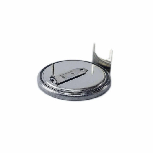 silver round battery synthesizer part with metal connectors on white background
